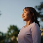 woman relaxing in nature - staying grounded to keep in the present moment