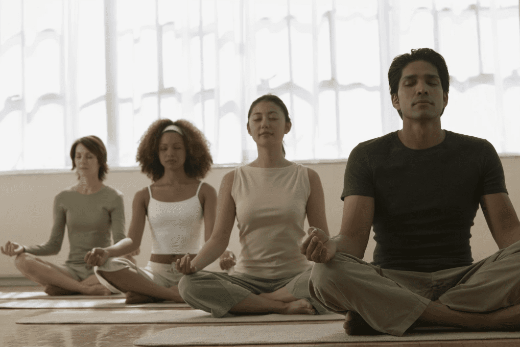 Four people meditating.