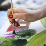 A woman painting on a canvas.