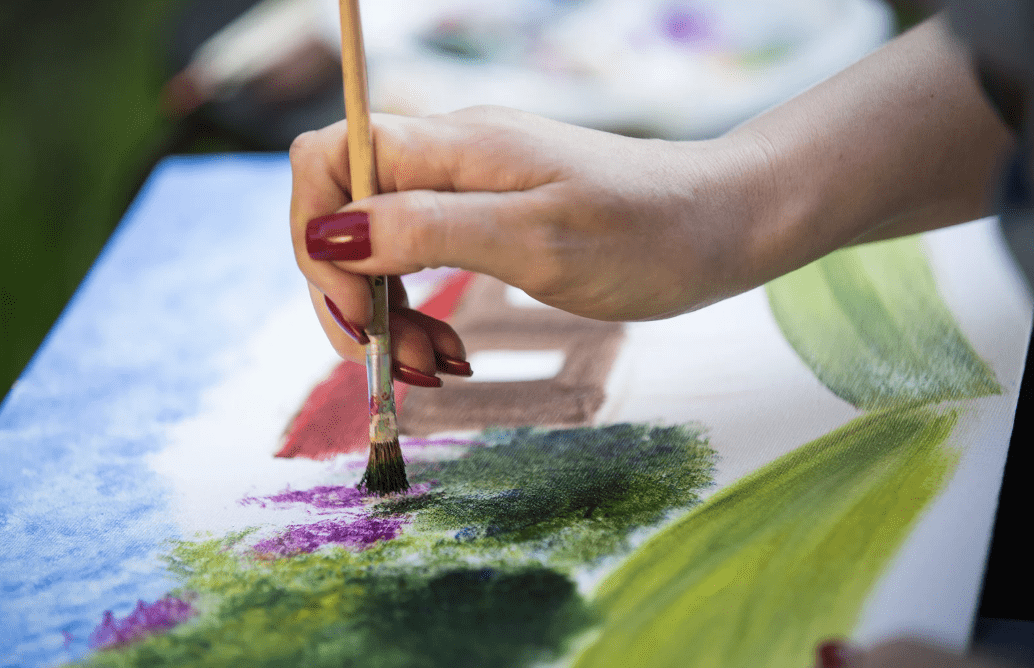 A woman painting on a canvas.
