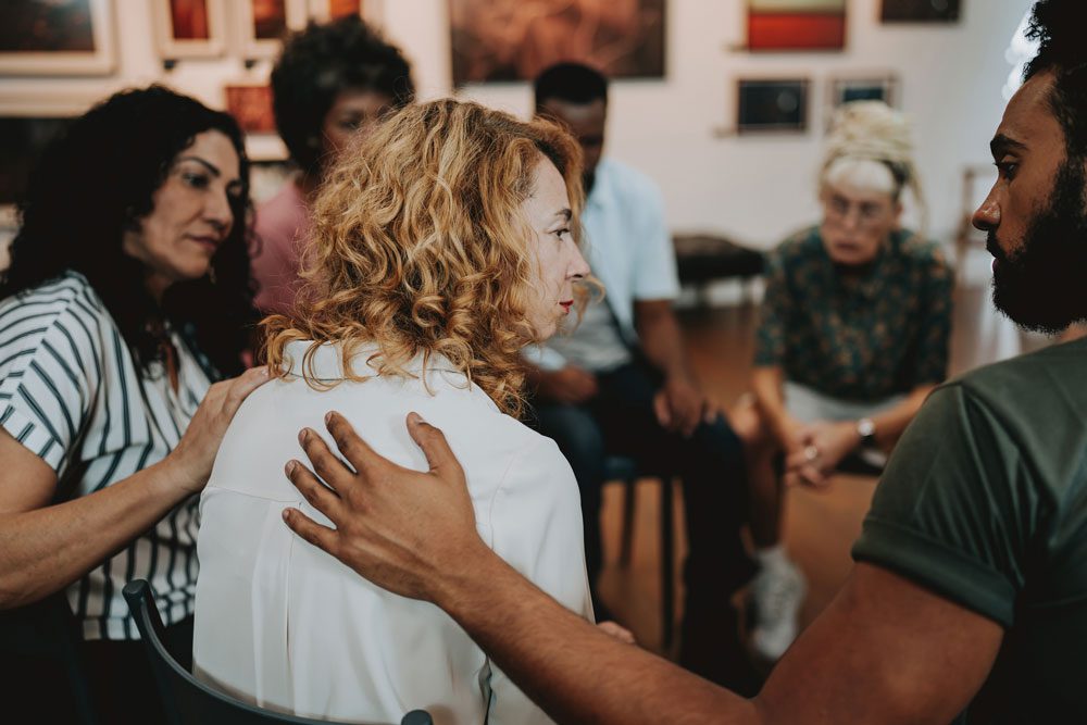 Diverse group of people sitting in a circle during a group therapy session, listening and sharing in a supportive environment. Intensive Outpatient Program IOP - Partial Hospitalization Program - PHP
