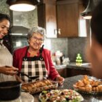 Mother and daughter talking while preparing food at kitchen counter at home